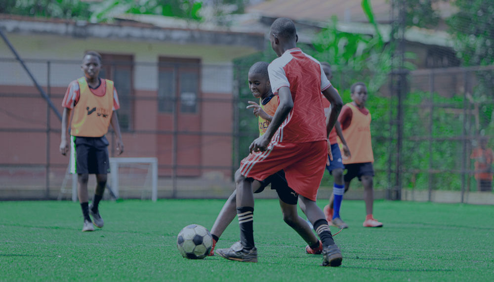 African teenagers playing football on a pitch