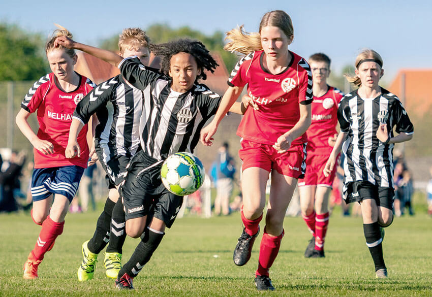 Teenage girls playing football