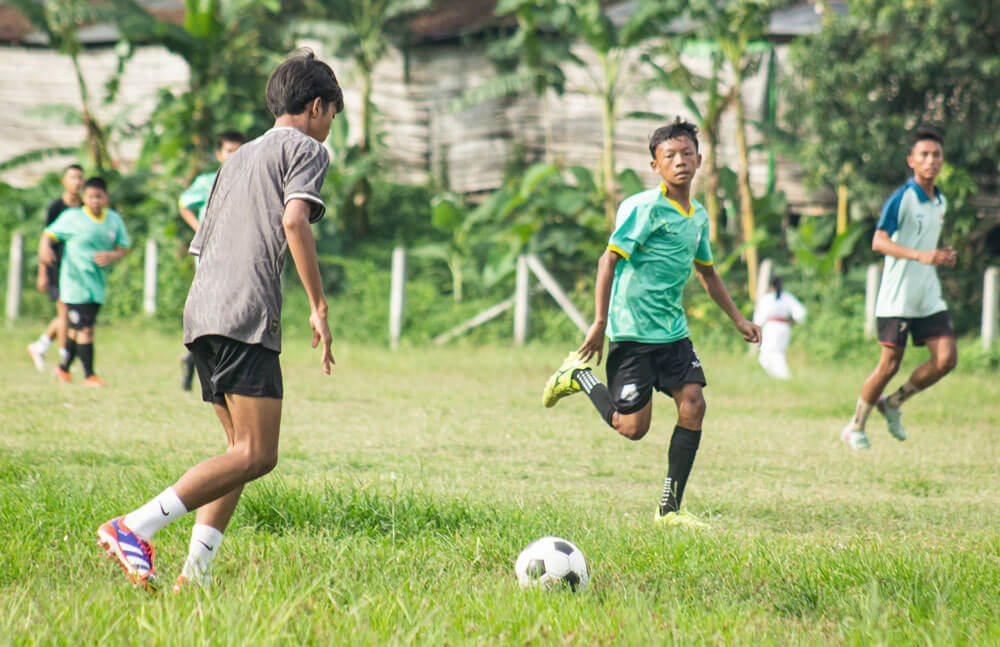 Asian teenagers playing football