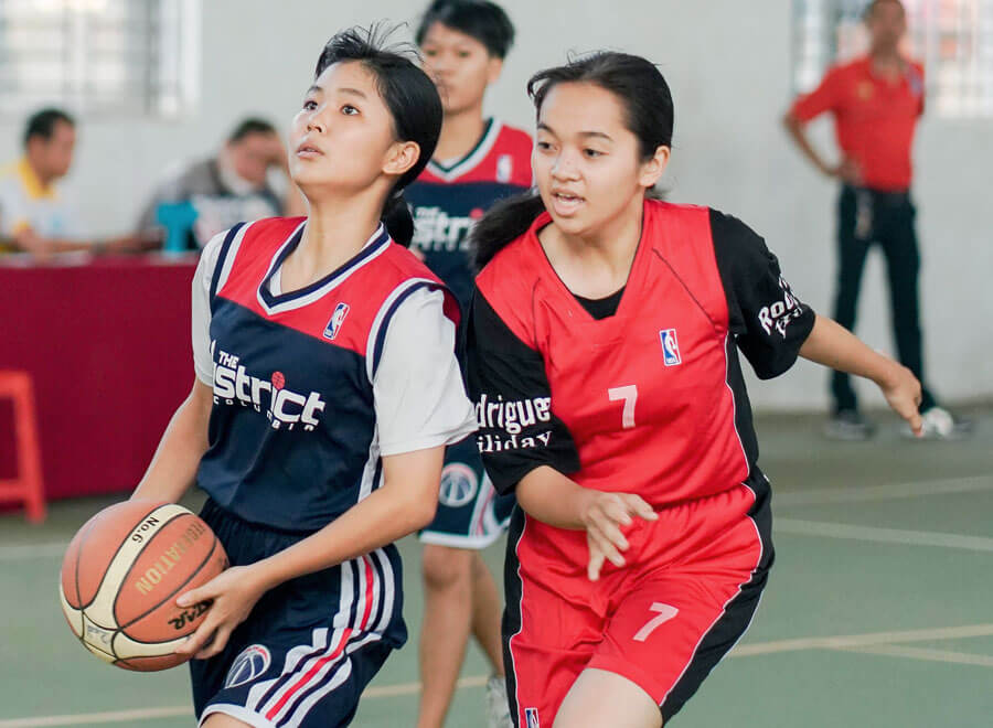 Female teenagers playing basketball